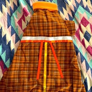 Dog coat with yellow, white, and orange ribbon.
